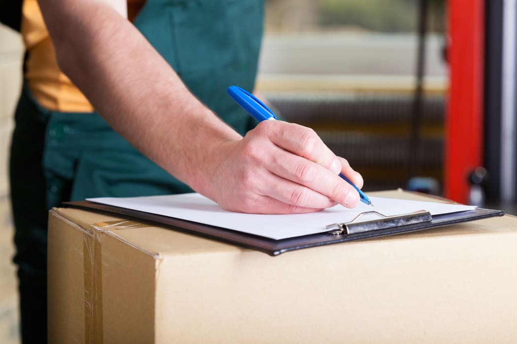 Close-up of a man's hand signing delivery document