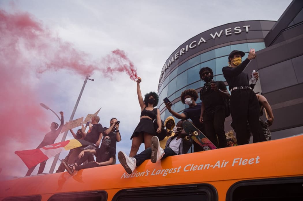 Demonstrators stand on a bus in the Fairfax district of Los Angeles on May 30, 2020 during a protest against the death of George Floyd, an unarmed black man who died while while being arrested and pinned to the ground by the knee of a Minneapolis police officer.