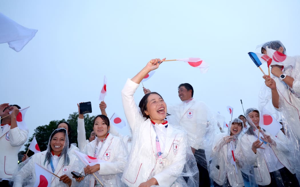 PARIS, FRANCE - JULY 26: Athletes of Team Japan wave their national flags as they cruise along the River Siene during the opening ceremony of the Olympic Games Paris 2024 on July 26, 2024 in Paris, France. (Photo by Michael Reaves / POOL / AFP)