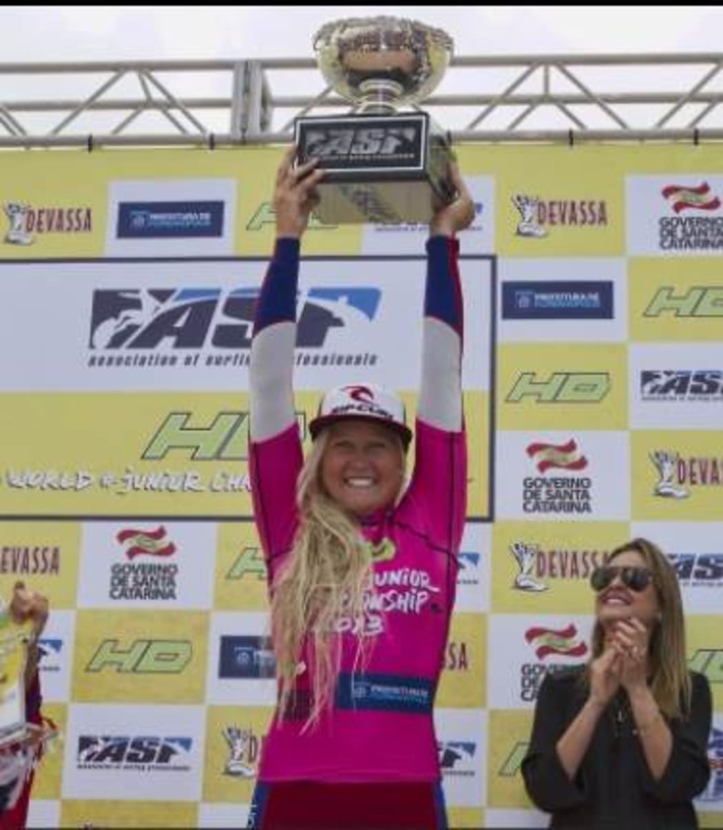 Ella Williams holding her world championship trophy aloft.