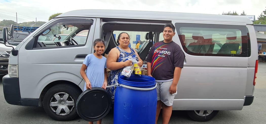 This family is packing needed supplies for family on Tongatapu