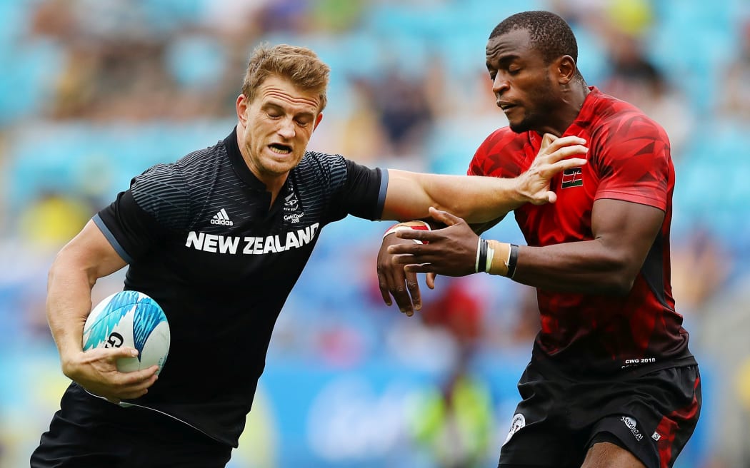 Scott Curry fends off a Kenyan tackler during their Commonwealth Games match.