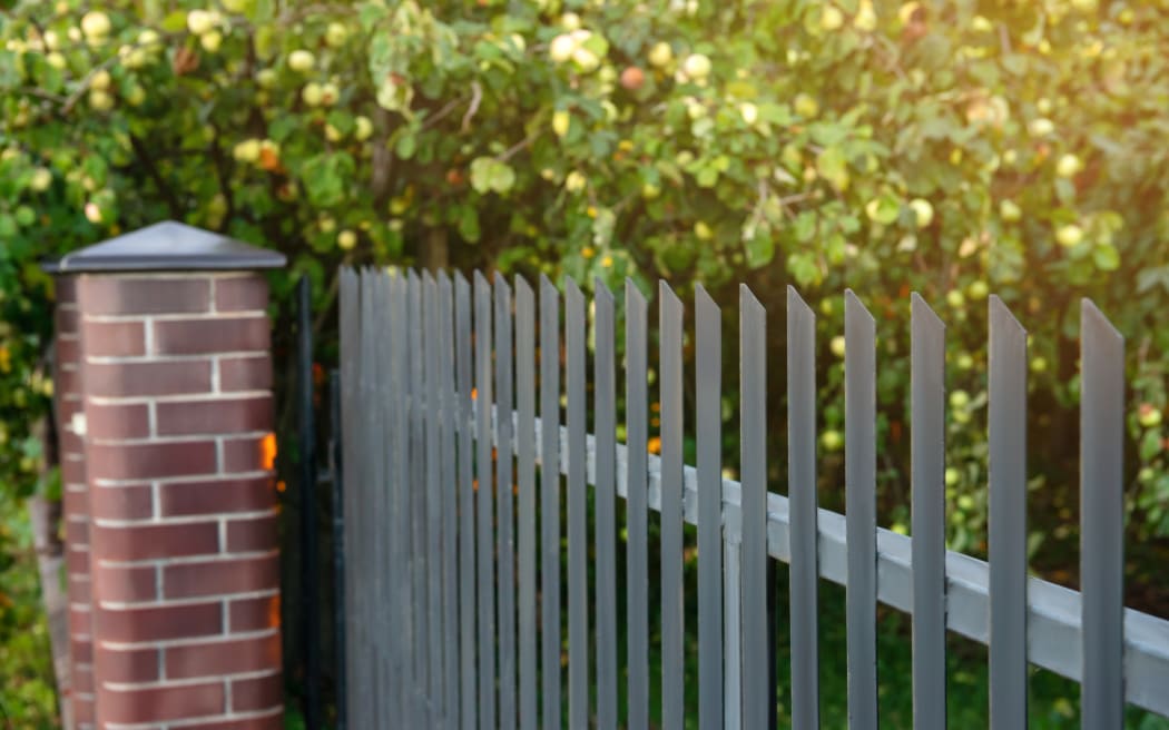 Beautiful brick fence with iron railing outdoors