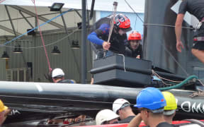 Peter Burling and Blair Tuke repairing a broken wing section.
