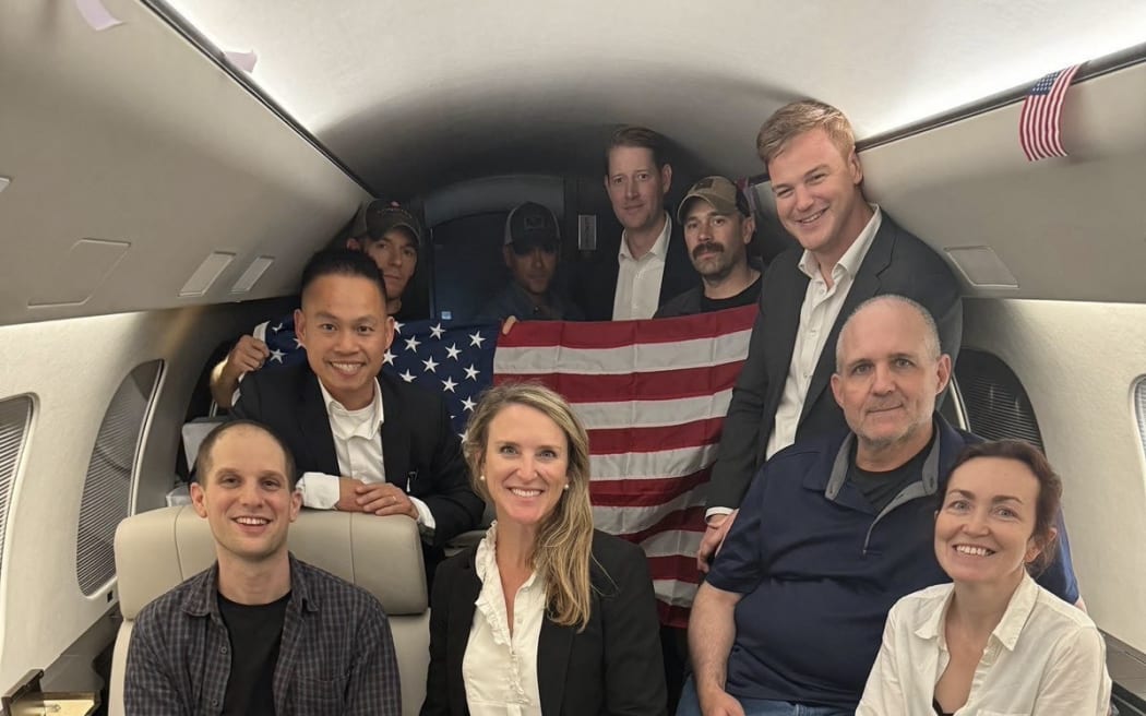 In this image released by the US Government, US journalist Evan Gershkovich (L), former US Marine Paul Whelan (2R) and US-Russian journalist Alsu Kurmasheva (R) are seen on a plane after their release from Russia on August 1, 2024. Gershkovich, Whelan, Kurmasheva and Russian opposition activist Vladimir Kara-Murza were part of a 24-prisoner swap with Russia.