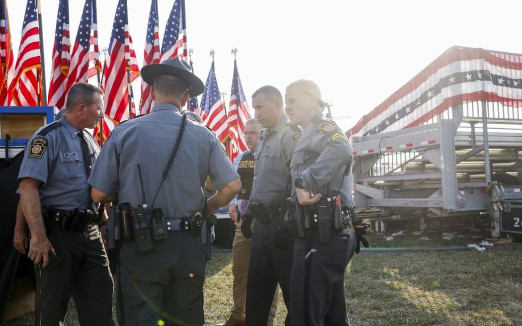 BUTLER, PENNSYLVANIA - JULY 13: Law enforcement agents stand near the stage of a campaign rally for Republican presidential candidate former President Donald Trump on July 13, 2024 in Butler, Pennsylvania. According to Butler County District Attorney Richard Goldinger, the suspected gunman is dead after injuring former President Trump, killing one audience member and injuring at least one other.   Anna Moneymaker/Getty Images/AFP (Photo by Anna Moneymaker / GETTY IMAGES NORTH AMERICA / Getty Images via AFP)