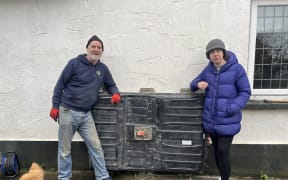 Eamon Stack (left) with a Nissan Leaf battery plugged into the outside of Hannah Daly's house.