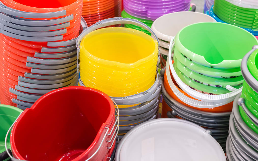 A stack of plastic bucket of different colours.