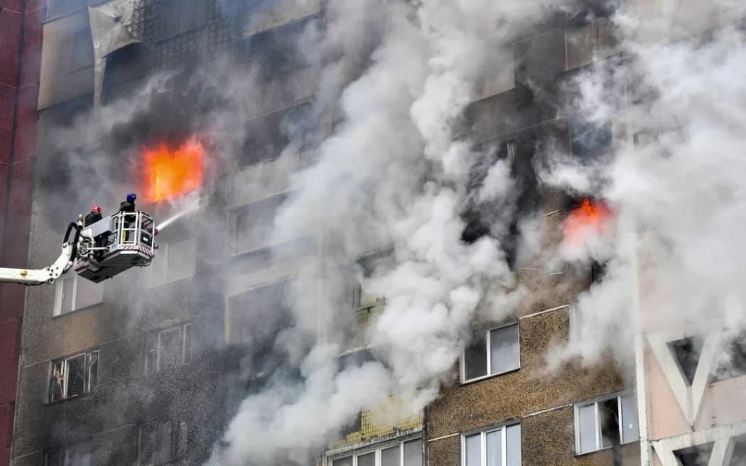 Ukrainian rescuers extinguish a fire in a residential building following a missile attack in Kyiv in February 2024.