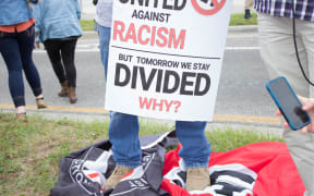 A man stands on a Nazi and Anti-Fascist flag at the University of Florida in Gainesville, Florida, United States.