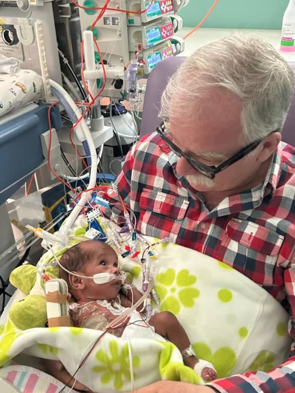 Manolos Aviation pilot Jurgen Ruh with Sawong at Sydney Children’s Hospital. Ruh flew Sawong and his conjoined twin Tom to Port Moresby General Hospital from their home in remote Morobe Province after they were born.