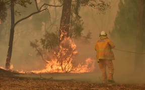 A fireman fights a bushfire to protect a property in Balmoral, 150 kilometres southwest of Sydney on December 19, 2019.