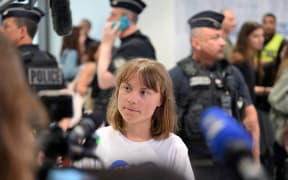 Swedish campaigner Greta Thunberg talks to journalists upon her arrival to Roissy-Charles de Gaulle Airport, as she left Israel on a flight to Sweden via France, after she was detained along with other activists aboard a Gaza-bound aid boat, on June 10, 2025. Thunberg departed Israel on a flight from Tel Aviv to Sweden (via France). Of the 12 people on board the Madleen carrying food and supplies for Gaza, five French activists were taken into custody after they refused to leave Israel voluntarily. (Photo by Hugo MATHY / AFP)