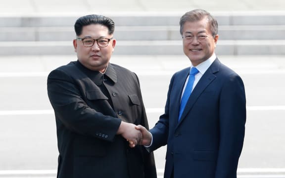 North Korea's leader Kim Jong Un shakes hands with South Korea's President Moon Jae-in at the Military Demarcation Line.
