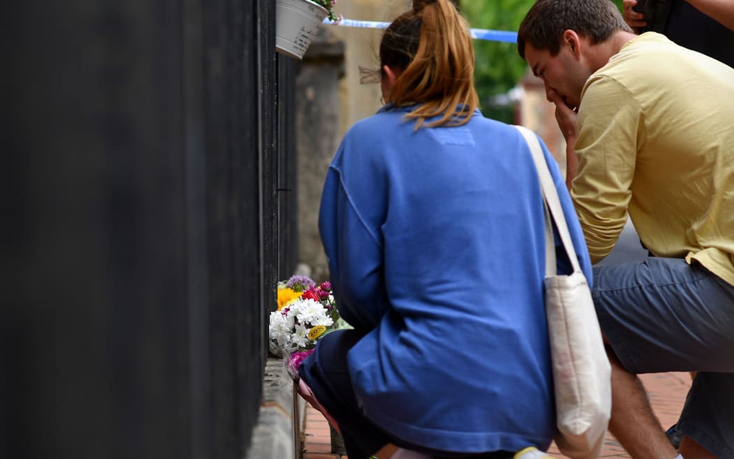 People leave flowers at a police cordon at the Abbey Gateway near Forbury Gardens park in Reading, west of London, on June 21, 2020 following a fatal stabbing incident the previous day. -
