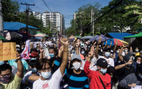 Protesters make the three-finger salute during a demonstration against the military coup in Yangon on 14 May, 2021.