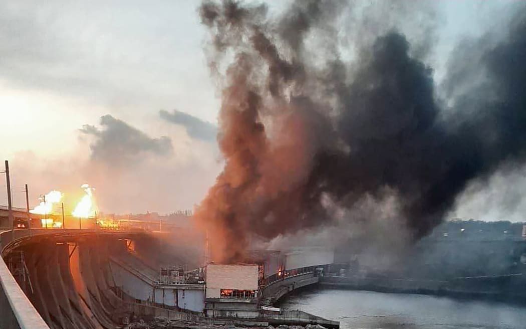This handout photograph released by Telegram Channel of Ukraine's Prime Minister Denys Shmyhal on 22 March, 2024, shows smoke and fire rising over the dam of Dnipro hydroelectric power plant after a missile attack in Zaporizhzhia, amid the Russian invasion in Ukraine.