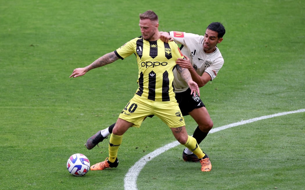 Phoenix's David Ball with Adelaide United's Juande during their A-League match in Wellington.