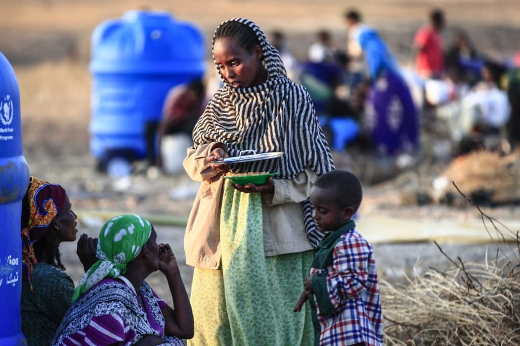 An Ethiopian refugee who fled intense fighting in their homeland of Tigray, speaks to a fellow refugee at the border reception centre of Hamdiyet, in the eastern Sudanese state of Kasala, on November 14, 2020.