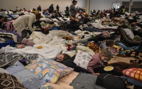 People rest in a temporary shelter for Ukrainian refugees, located near the Polish-Ukrainian border in a former shopping center in Przemysl, Poland, on March 8, 2022.