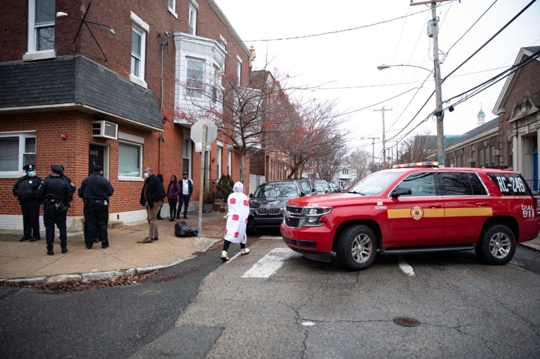 PHILADELPHIA, PA - JANUARY 05: Police and residents are seen in the Fairmount neighborhood on January 5, 2022 in Philadelphia, Pennsylvania. A fire killed 13 people, including seven children, in a Philadelphia rowhouse on Wednesday morning, officials said.