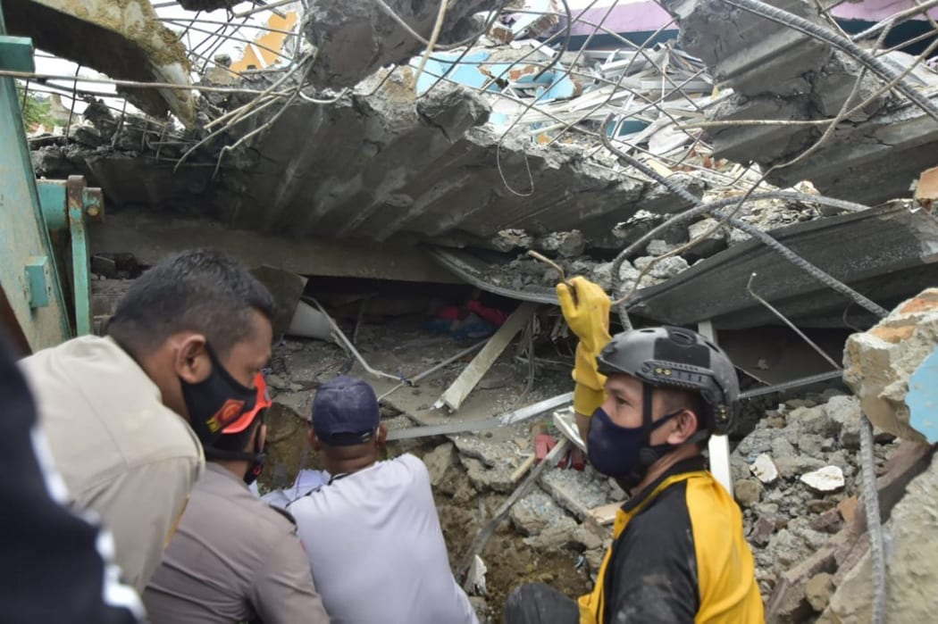 EDITORS NOTE: Graphic content / Rescuers search for survivors at the Mitra Manakarra hospital in Mamuju city on January 15, 2021, where as many as 20 patients and staff are trapped when a 6.2-magnitude earthquake rocked  Sulawesi island.