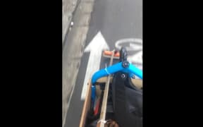 Marcus McShane sweeps the bike path with his home made broom on the bike