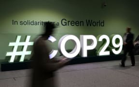 Attendees walk past the COP29 logo during the United Nations Climate Change Conference (COP29) in Baku, Azerbaijan, on 21 November 21, 2024.