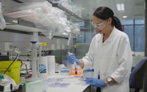 Woman with protective glasses on works in lab