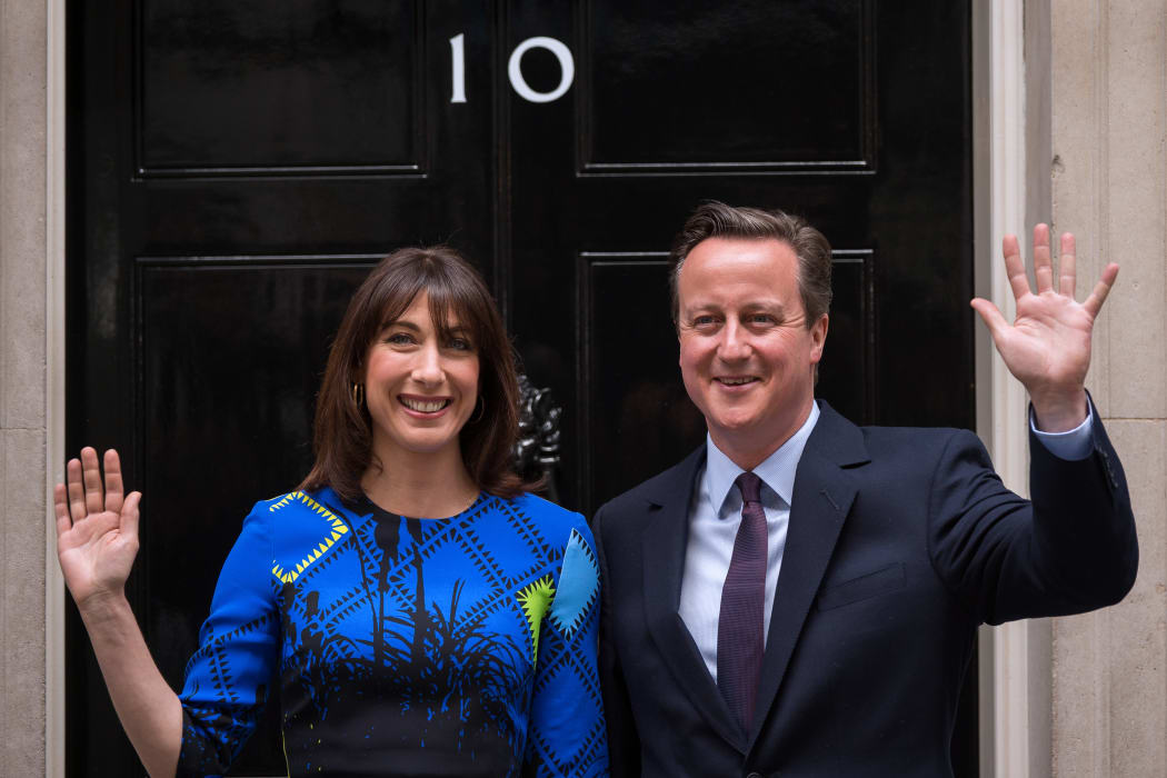 David Cameron and his wife Samantha pose for pictures as they arrive back at 10 Downing Street in London on 8 May.