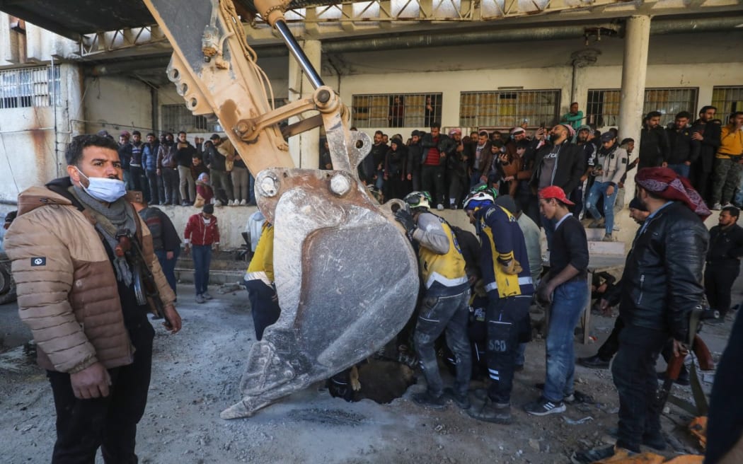 People gather as Syrian White Helmets civil defence members and experts search for potential hidden basements at the Sednaya prison in Damascus on December 9, 2024.