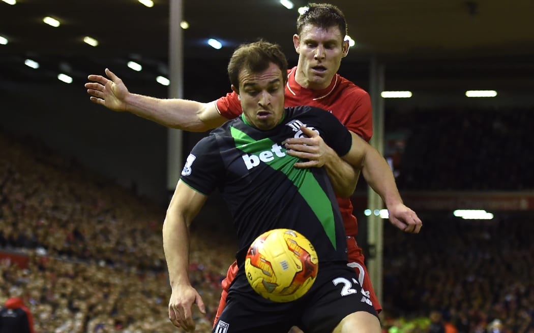 Liverpool's English midfielder James Milner (R) vies with Stoke City's Swiss forward Xherdan Shaqiri during the English League Cup semi-final second leg at Anfield