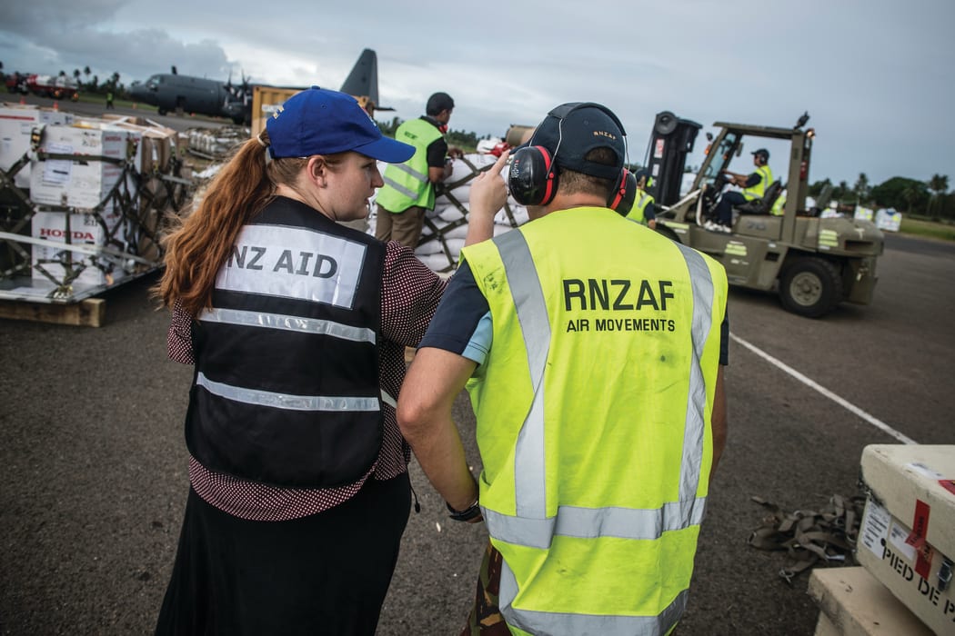 Aid workers and the Royal New Zealand Air Force personnel loading supplies
