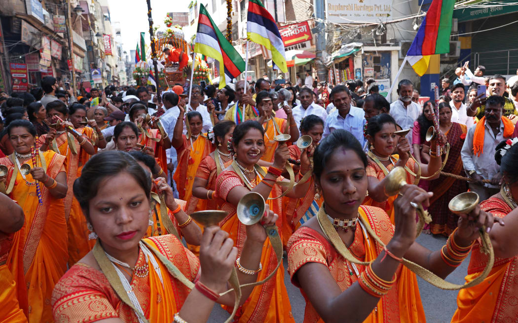 Women dressed in traditional attire dance during a religious procession on the occasion of 'Maha Shivratri' Hindu festival in Varanasi on March 8, 2024.