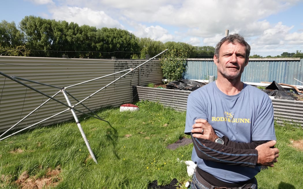 Roy Mattock stands in front of the broken clothesline at the back of the house.