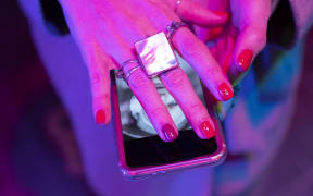 Close-up of hand of woman with red manicure covering smart phone. (Photo by Tom Merton/CAIA IMAGE/SCIENCE PH / NEW / Science Photo Library via AFP)