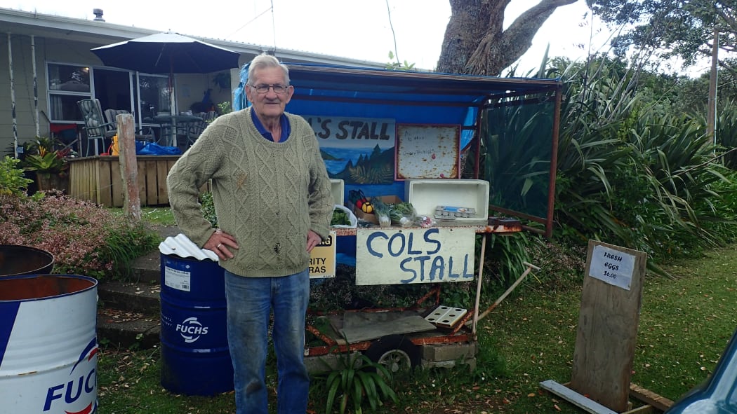 Retired railwayman Barry Coll poses next to his roadside stall in Northland.