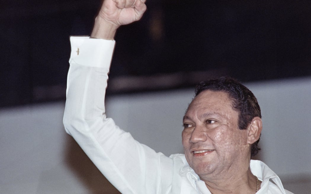 Leader of the Panamanian Defense Forces General Manuel Noriega salutes a crowd in Panama City on May 18, 1989. Noriega made his first public appearance in two weeks at a progovernment rally. (Photo by R REYNA / AFP)