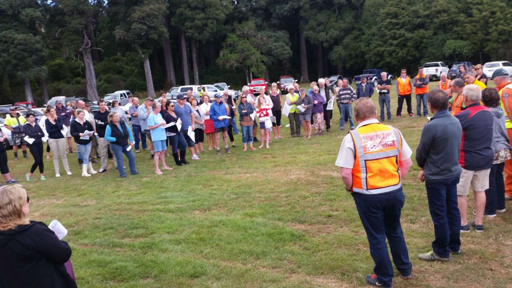 Members of the public gather for an update on Friday afternoon.