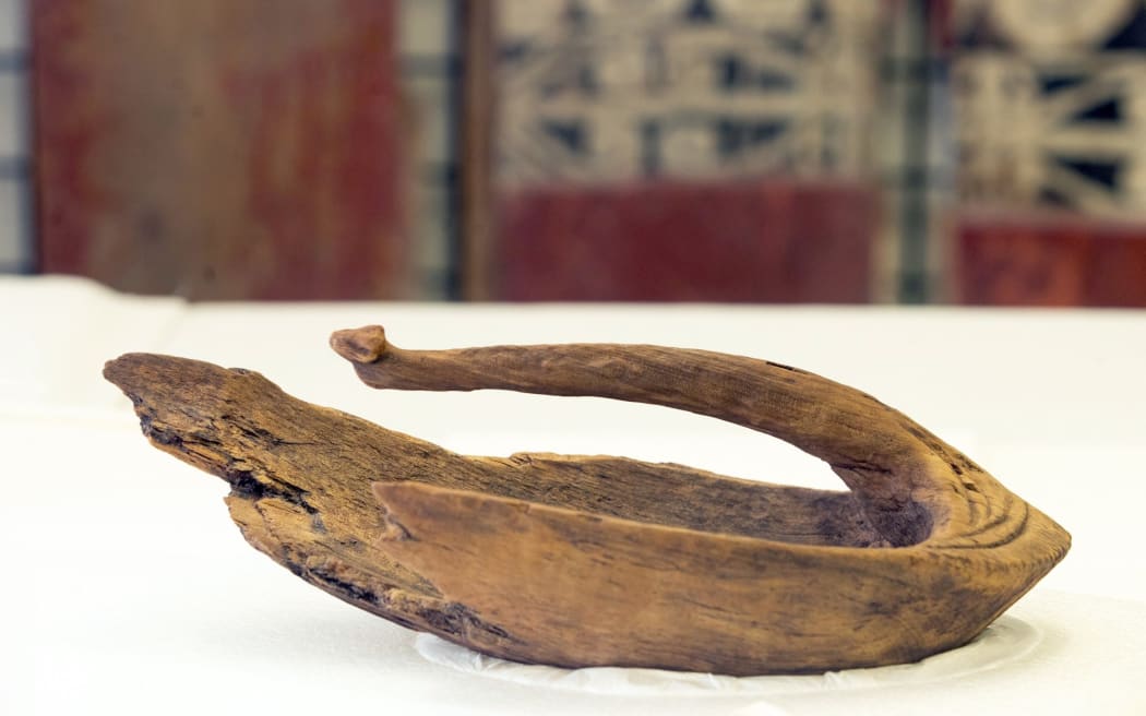 Te Pou Arahi cultural heritage manager Dean Flavell and museum collection specialist Chelsea Tairi with a 14th century wooden canoe bailer.