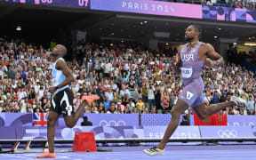 Botswana's Letsile Tebogo, left, crosses the finish line ahead of US's Noah Lyles in the men's 200m semi-final at the Paris Olympics.