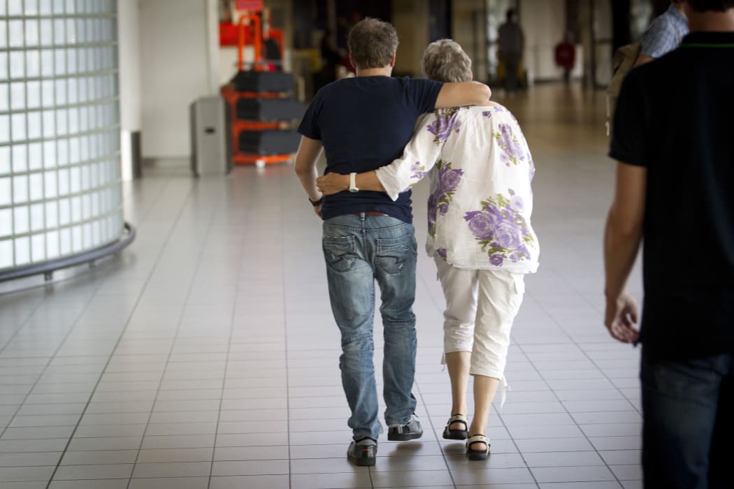 A couple at Schipol Airport, Amsterdam, walk to get information on the Malaysia Airlines plane.