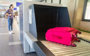 waiting luggage through point of checking the scanner. Baggage X-ray machine band on the conveyor belt at the airport.