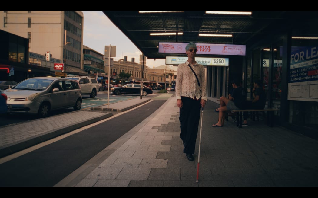 Ari Kressens walks down Karangahape Road using his cane