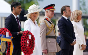 Britain's Prime Minister Rishi Sunak (L), Britain's Queen Camilla (2L), Britain's King Charles III (C), France's President Emmanuel Macron (2R) and his wife Brigitte Macron attend a wreath laying ceremony during the UK Ministry of Defence and the Royal British Legion's commemorative ceremony marking the 80th anniversary of the World War II "D-Day" Allied landings in Normandy, at the World War II British Normandy Memorial near the village of Ver-sur-Mer which overlooks Gold Beach and Juno Beach in northwestern France, on June 6, 2024. The D-Day ceremonies on June 6 this year mark the 80th anniversary since the launch of 'Operation Overlord', a vast military operation by Allied forces in Normandy, which turned the tide of World War II, eventually leading to the liberation of occupied France and the end of the war against Nazi Germany. (Photo by Gareth Fuller / POOL / AFP)