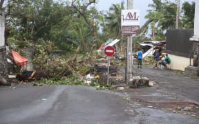 People stand by fallen trees on April 25, 2019 in Moroni after tropical storm Kenneth hit Comoros.