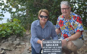 Cate Walker and Paul Morrissey beside the grave of Cate's late mother Gloria Walker. Cate has repainted and refreshed her mother's grave since it was left abandoned.