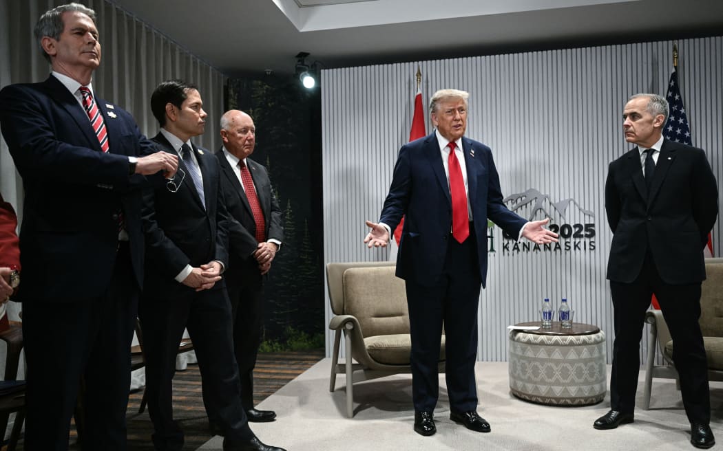 US President Donald Trump speaks as Canadian Prime Minister Mark Carney (R) looks on as they meet during the Group of Seven (G7) Summit at the Pomeroy Kananaskis Mountain Lodge in Kananaskis, Alberta, Canada on June 16, 2025. Also pictured, L/R, are US Secretary of Treasury Scott Bessent, US Secretary of State Marco Rubio and US Ambassador to Canada Pete Hoekstra. (Photo by Brendan SMIALOWSKI / AFP)