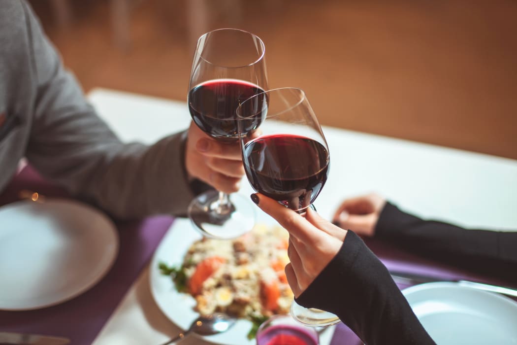 Couple sharing a meal and a glass of wine.