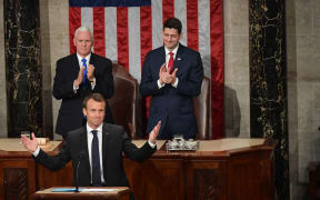 House Speaker Paul Ryan (R) and US Vice President Mike Pence applaud after France's President Emmanuel Macron addressed a joint meeting of Congress.